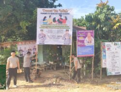 BHABINKAMTIBMAS POLSEK MANIS MATA PASANG SPANDUK PILKADES DAMAI DI DESA RATU ELOK