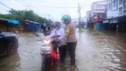 Bhabinkamtibmas Polsek Benua Kayong Laksanakan Pengaturan Lalu Lintas dan Bantu Warga Terdampak Banjir Rob di Jalan Pawan 1